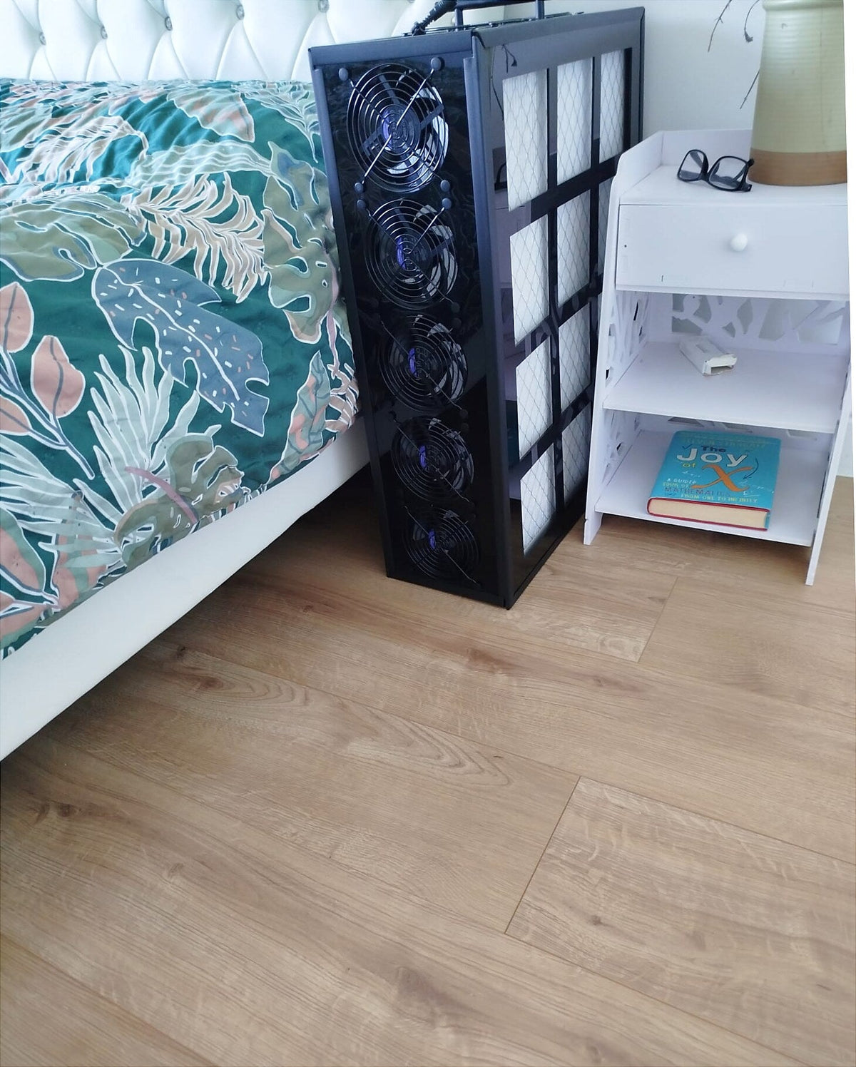 Luggable 5-Fan air purifier in Obsidian black beside a bed, slim bedside footprint, whisper-quiet